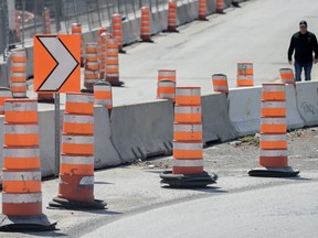 A man detours around construction cones in Montreal, Tuesday, April 25, 2023.