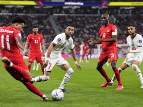 Canada's Tajon Buchanan, left, clears the ball in front Morocco's Hakim Ziyech during World Cup soccer action against Morocco in Doha, Qatar, on Dec. 1, 2022. The City of Toronto and Maple Leaf Sports and Entertainment have drafted an agreement detailing their proposed partnership surrounding the 2026 FIFA World Cup, which aims to shield the company from suffering any losses related to matches in Toronto.