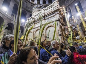 Christian pilgrims walk with palm fronds as they circle in a procession around the Edicule, traditionally believed to be the burial site of Jesus Christ, at the Church of the Holy Sepulchre in Jerusalem on April 2, 2023, Palm Sunday according to Catholics.
