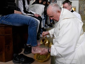 This photo taken and issued as a handout on April 6, 2023 y the Vatican Media shows Pope Francis performing the "Washing of the Feet" of twelve young detainees at the "Casal del Marmo" Penal Institute for minors in Rome, as part of celebrations of the Holy Week.