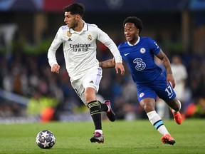 Marco Asensio of Real Madrid runs with the ball whilst under pressure from Raheem Sterling of Chelsea during the UEFA Champions League quarter-final second leg match between Chelsea FC and Real Madrid at Stamford Bridge on April 18, 2023 in London.