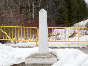 A Canada/US border marker is shown on Roxham road in Hemmingford, Que., Saturday, March 25, 2023.