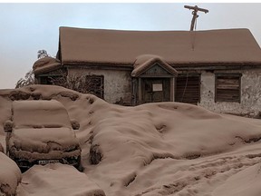 A house and car are seen covered in volcanic dust following the eruption of Shiveluch volcano in Kamchatka region, Russia April 11, 2023.