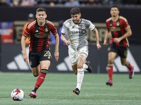 Atlanta United midfielder Matheus Rossetto, left, drives down field past Toronto FC midfielder Jonathan Osorio, centre, during the second half of an MLS soccer match, Saturday, March 4, 2023, in Atlanta. Osorio is the latest Toronto FC player hit by the injury bug.