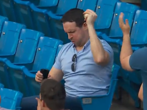 A Blue Jays fan celebrates catching a foul ball.