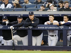 Aaron Judge centre) of the New York Yankees looks on from the dugout.