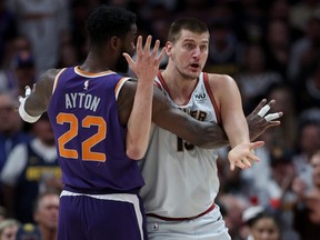 Nikola Jokic of the Denver Nuggets looks for a call while being guarded by Deandre Ayton of the Phoenix Suns during Game 5.