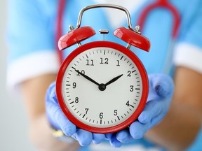 Hospital doctor nurse health care staff holding clock wait times stock photo getty images