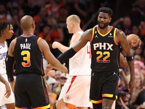 Deandre Ayton (right) of the Phoenix Suns high fives Chris Paul.
