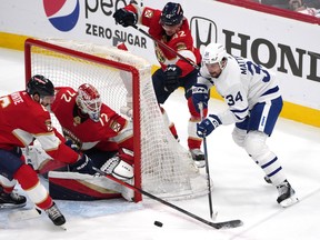 Toronto Maple Leafs centre Auston Matthews passes the puck to the front of the net as Florida Panthers' Gustav Forsling closes in during Game 4.