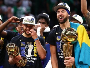 Stephen Curry and Klay Thompson of the Golden State Warriors celebrate with the Bill Russell NBA Finals Most Valuable Player Award and the Larry O'Brien Championship Trophy after defeating the Boston Celtics 103-90 in Game Six of the 2022 NBA Finals at TD Garden on June 16, 2022 in Boston, Massachusetts.