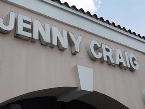 A Jenny Craig sign hangs on the wall outside of the weight loss store on April 28, 2023 in Miami, Florida. (Photo by Joe Raedle/Getty Images)
