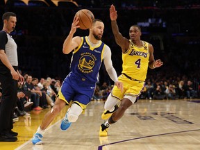 Stephen Curry #30 of the Golden State Warriors takes a pass in front of Lonnie Walker IV #4 of the Los Angeles Lakers