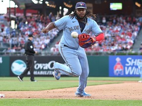 Vladimir Guerrero Jr.  of the Toronto Blue Jays looks to track down the errant throw from Bo Bichette during the 10th inning against the Phillies at Citizens Bank Park on May 10, 2023 in Philadelphia.