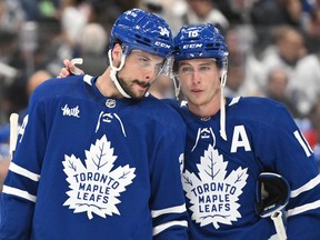 Toronto Maple Leafs forward Mitch Marner (16) speaks to Auston Matthews.