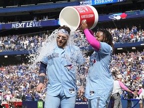 Toronto Blue Jays first baseman Vladimir Guerrero Jr. (27) douses catcher Danny Jansen (9) with ice water after a win over the Atlanta Braves.