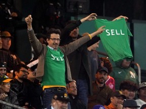 Oakland Athletics fans display shirts directed at management.