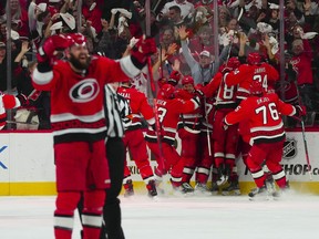 Carolina Hurricanes right winger Jesper Fast (71) is congratulated by his teammates after his game winning goal against the New Jersey Devils.