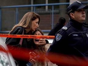 A parent escorts her child following a shooting at a school in the capital Belgrade on May 3, 2023.