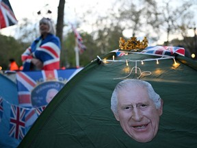 A crown sits on a tent, decorated with a portrait of King Charles III on The Mall in central London, on May 4, 2023, ahead of the coronation weekend.