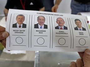 A Turkish national living in Kuwait, holds a ballot bearing the images of presidential candidates, during voting for the presidential elections at the Turkish embassy in Kuwait City on May 5, 2023.