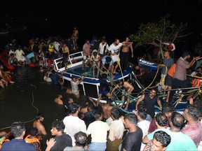 In this photograph taken on May 7, 2023, people carry out rescue operation at the site of a boat accident in Tanur, in Malappuram district of India's Kerala state.