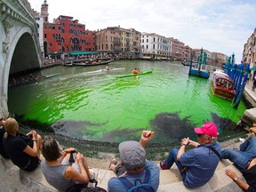 A photo taken on May 28, 2023 by Italian news agency Ansa, shows fluorescent green waters below the Rialto Bridge in Venice's Grand Canal.