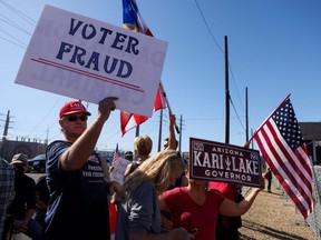 Supporters of Republican candidate for Arizona Governor Kari Lake and Republican U.S. Senate candidate Blake Masters protest outside the Maricopa County Tabulation and Election Center as vote counting continues inside, in Phoenix, Nov. 12, 2022.