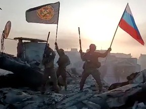Members of Wagner group wave Russian flag
