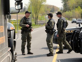 Police block off the area outside a home on Laval Street in Bourget, Ont., on May 11, 2023.