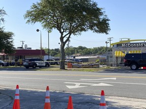 Police vehicles sit parked in front of a McDonald's restaurant as police investigate a shooting in which multiple people were killed Thursday, May 4, 2023, in Moultrie, Ga.  (Kamira Smith/The Moultrie Observer via AP)