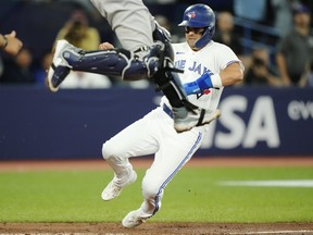 Blue Jays' Whit Merrifield scores on a sacrifice fly off the bat of Vladimir Guerrero Jr. as New York Yankees catcher Kyle Higashioka leaps in the air during the seventh inning in Toronto, on Thursday, May 18, 2023.