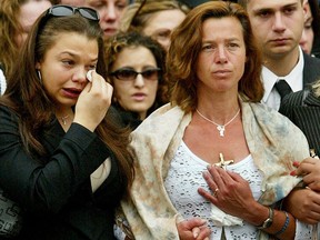Maria Jones (right), the mother of murdered 10-year-old Holly Jones, listens with her daughter Natasha, 17, (left) as a song is played during Holly's funeral service at St. Vincent de Paul Roman Catholic Church in Toronto, Tuesday, May 20, 2003.