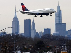 A Delta Airlines jet comes in for a landing in front of the Empire State Building and Manhattan skyline at LaGuardia Airport in New York City, Jan. 11, 2023.