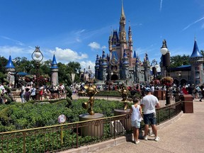 People gather ahead of the "Festival of Fantasy" parade at the Walt Disney World Magic Kingdom theme park in Orlando, Fla., July 30, 2022.