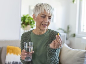 Mature woman taking a vitamin.