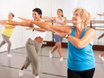 Group of dancers exercising modern dance movements in large room