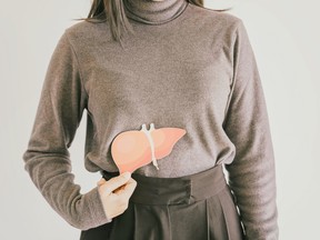 Woman holding paper liver cutout.