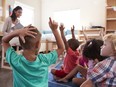 Pupils at school raising hands to answer question