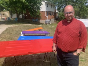 Rev. Kevin George stands beside doors that a youth group at St. Aidan's Anglican Church painted rainbow colours to display as a sign of solidarity with the LGBTQ+ community. Church officials arrived to discover that one of the doors had been vandalized with anti-trans graffiti overnight on Sunday May 28, 2023. Dale Carruthers / The London Free Press