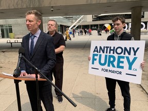 Mayoral candidate Anthony Furey, left, speaks to media outside City Hall on Tuesday, May 16, 2023.