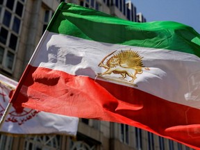 A flag is waved in front of Palais Coburg where closed-door nuclear talks with Iran are taking place in Vienna, Austria, Aug. 4, 2022.