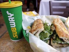In this Feb. 23, 2018, file photo, the Subway logo is seen on a soft drink cup next to a sandwich at a restaurant in Londonderry, N.H. (AP Photo/Charles Krupa, File)
