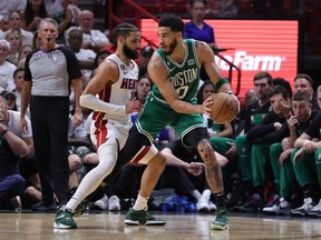Jayson Tatum, right, of the Boston Celtics drives against Caleb Martin of the Miami Heat