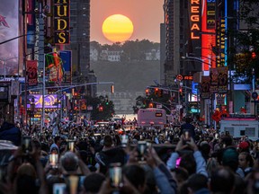 The sun sets in alignment with Manhattan streets running east-west, also known as Manhattanhenge