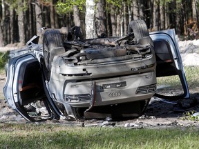 A view shows a damaged white Audi Q7 car lying overturned on a track next to a wood, after Russian nationalist writer Zakhar Prilepin was allegedly wounded in a bomb attack in a village in the Nizhny Novgorod region, Russia, May 6, 2023.