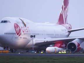 Cosmic Girl, a Virgin Boeing 747-400 aircraft sits on the tarmac with Virgin Orbit's LauncherOne rocket attached to the wing,