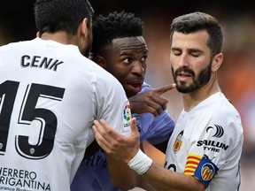 Real Madrid's Vinicius Junior gestures towards a fan after witnessing abuse as Valencia's Jose Gaya and Cenk Ozkacar attempt to restrain him in Valencia, Spain, May 21, 2023.