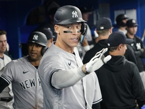 New York Yankees designated hitter Aaron Judge celebrates in the dugout after hitting a two run home run against the Toronto Blue Jays during the eighth inning at Rogers Centre in Toronto, May 16, 2023.
