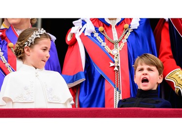 Princess Charlotte of Wales and Prince Louis of Wales stand on the Buckingham Palace balcony as they wait for the Royal Air Force fly-past in central London on May 6, 2023, after the coronations of King Charles III and Queen Camilla.